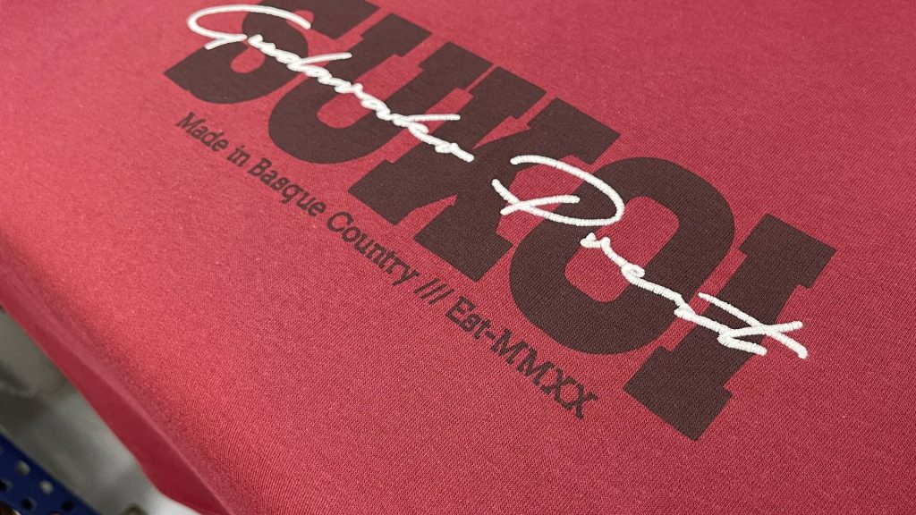 sudadera roja de marca sukoi que combina una serigrafía en color negro y un bordado por encima en color blanco