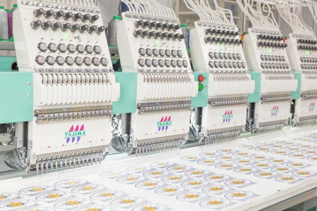 Bordado en serie de parches con máquina Tajima multicabezal en taller industrial de Bordado Express