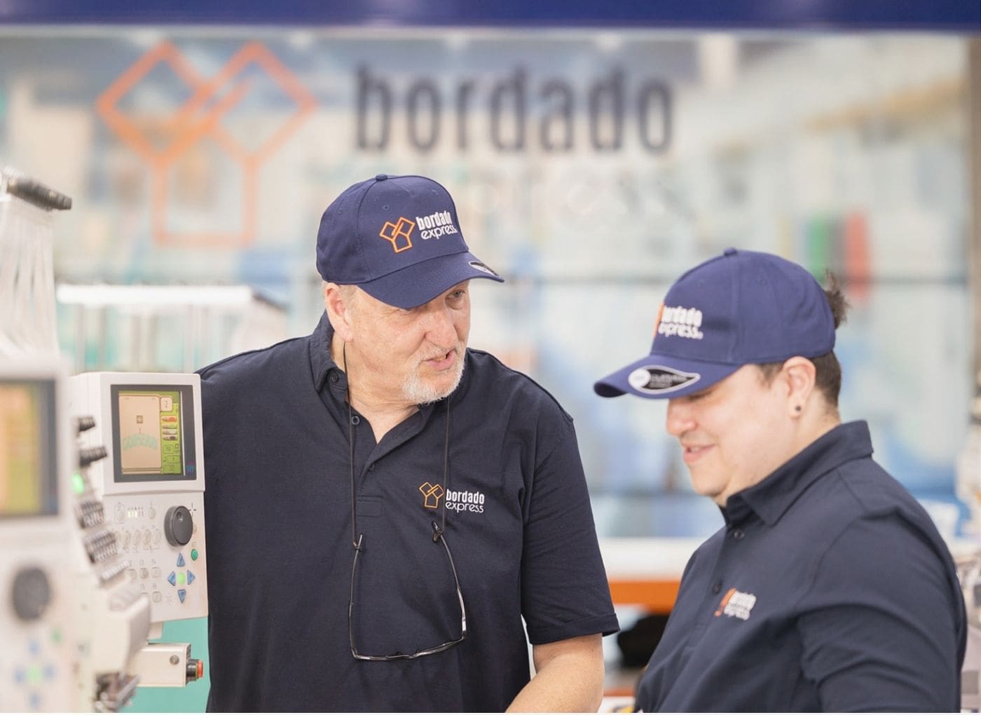 Formación de un operador junto a una máquina de bordado industrial en Bordado Express