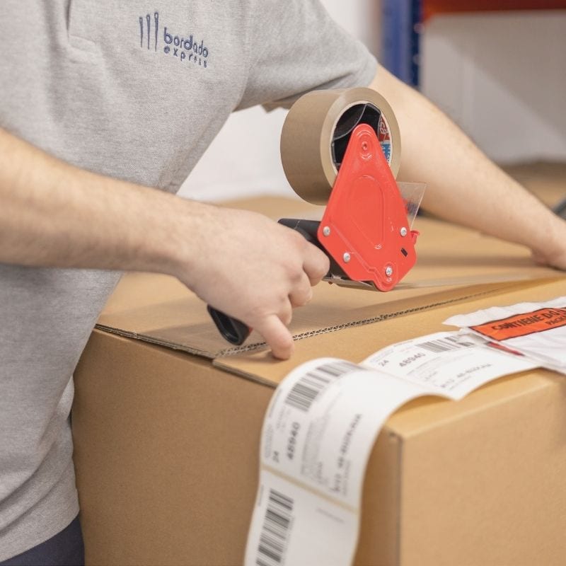 Preparación de envío a pedido del cliente en cajas con precinto neutro